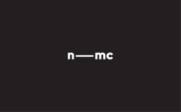 Logo for nmc featuring white minimalist typography with a horizontal line connecting the letters on a dark background.
