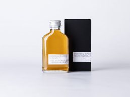 Visual Brain Gravity portfolio mockup showing amber glass bottle with silver cap and black packaging box for Everything Beaut