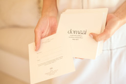 Minimalist white brochure mockup for domasi spa services held in hands, featuring elegant typography and clean layout design