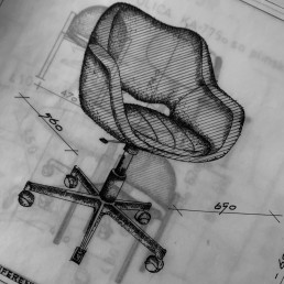 Technical drawing of an office chair with dimensions, featuring cross-hatched shading and detailed base structure on graph pa