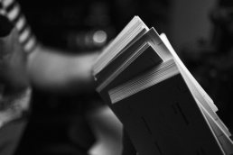 Open book with pages fanned out in black and white photography with shallow depth of field and moody lighting