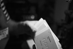 Black and white photograph showing nomia branded documents or packaging materials with clean, minimal design aesthetic