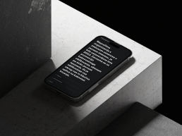 Black smartphone mockup on white concrete surface displaying Brumen text in white typography against dark background with dra