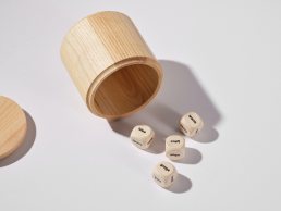 Brand Randomizer wooden dice set with cylindrical container, featuring words like 