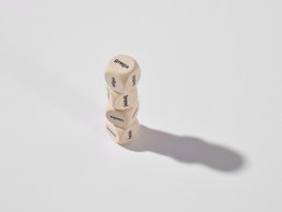 Four wooden dice stacked vertically displaying words 